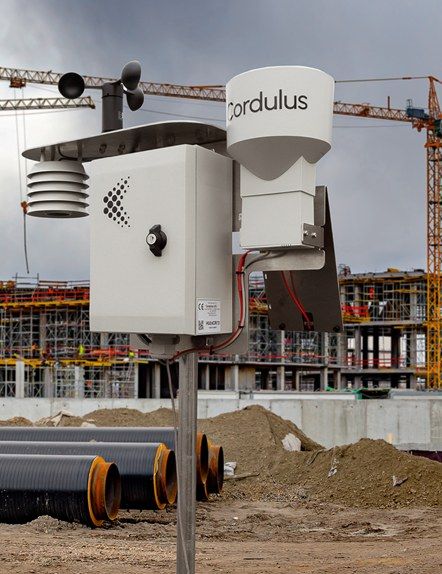 Wetterstation direkt auf der Baustelle montiert, im Hintergrund Betonfertigteile und ein Baukran